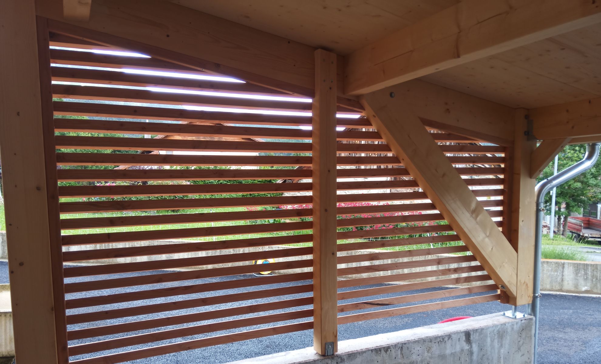 Abri bois ajouré offrant un espace protégé et confortable, tout en laissant circuler l’air et la lumière