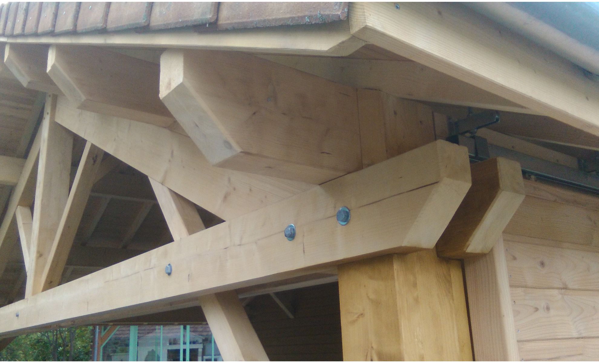 Charpente bois robuste et élégante d’un abri voiture, conçue avec soin pour allier solidité et esthétique