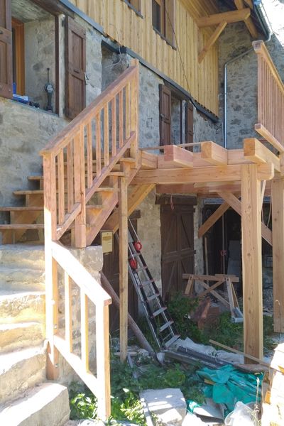 Transformation en cours d’un balcon bois en terrasse élargie, durant la rénovation d’une bâtie ancienne à Champoléon