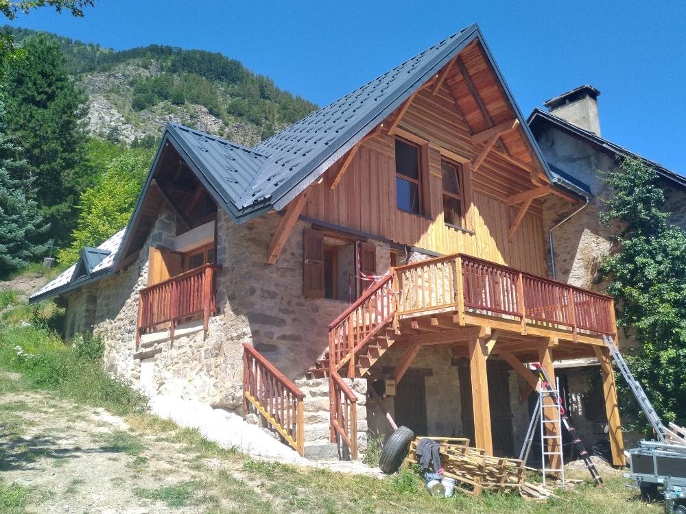 Terrasse en bois presque finalisée, vers la fin du chantier de rénovation d’une bâtie ancienne à Champoléon