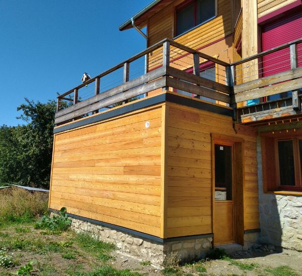Extension maison avec terrasse sur le toit, offrant un espace extérieur supplémentaire pour profiter du soleil