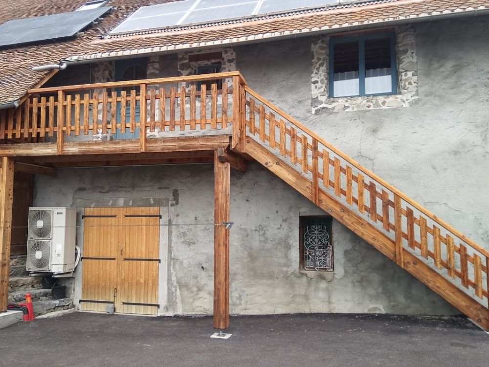 Vue d’une terrasse en bois rénovée, sablée puis relasurée pour retrouver son aspect d’origine