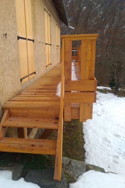 Terrasse en bois surélevée, facilitant l’accès fluide depuis des porte-fenêtres légèrement en hauteur