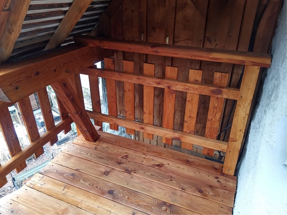 Terrasse en bois rénovée après sablage et relasure sous le toit
